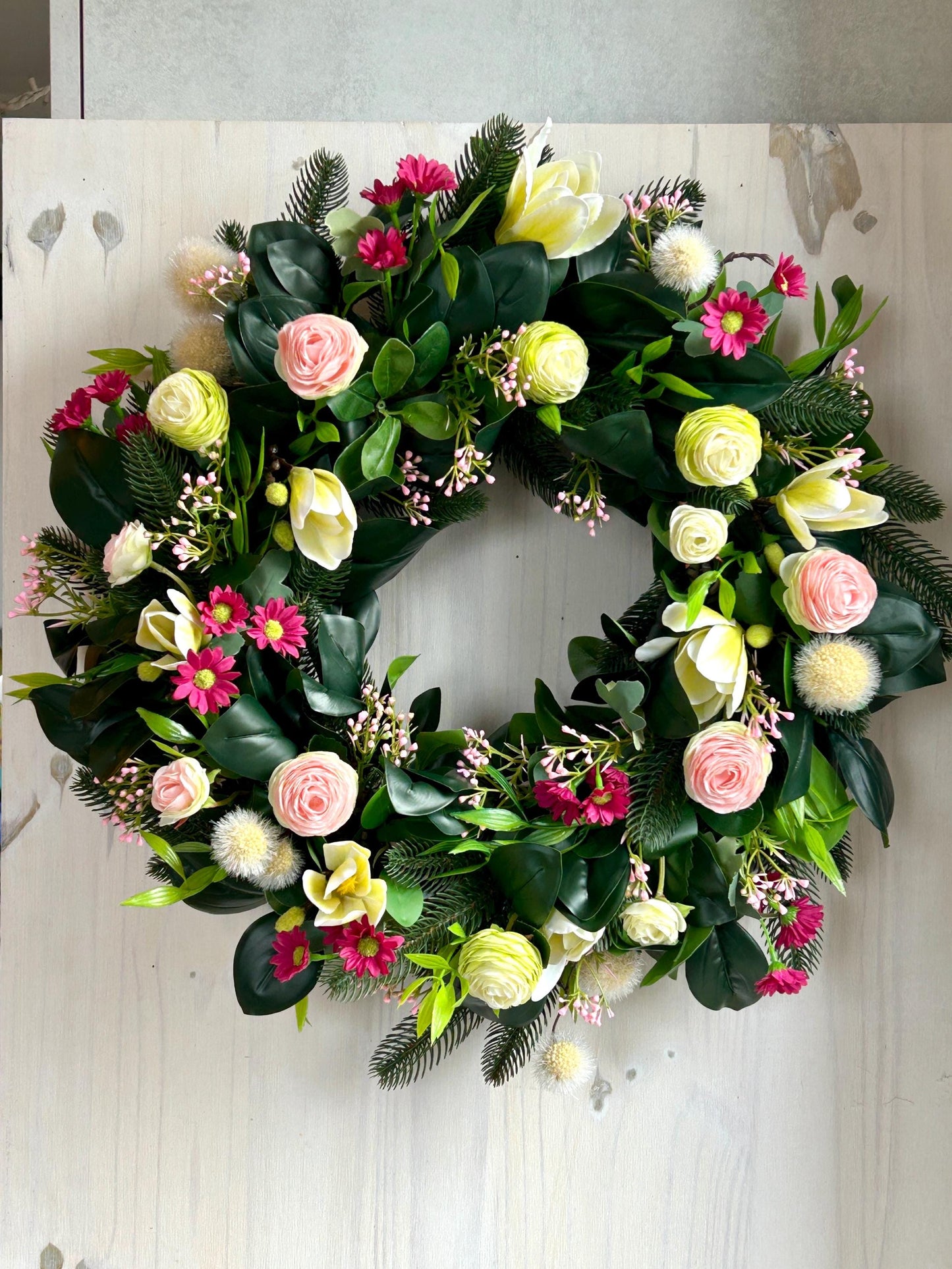 Couronne de printemps en plantes et de fleurs artificielles.