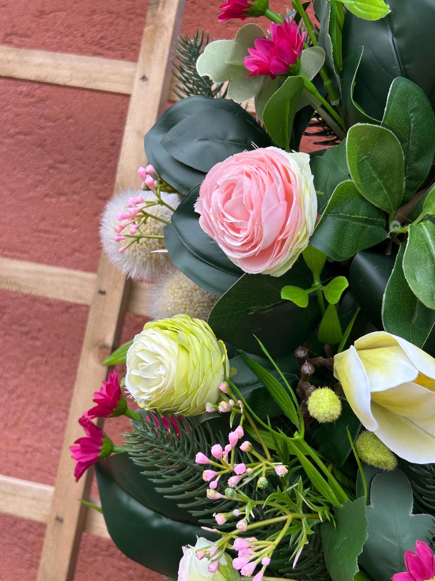 Couronne de printemps en plantes et de fleurs artificielles.