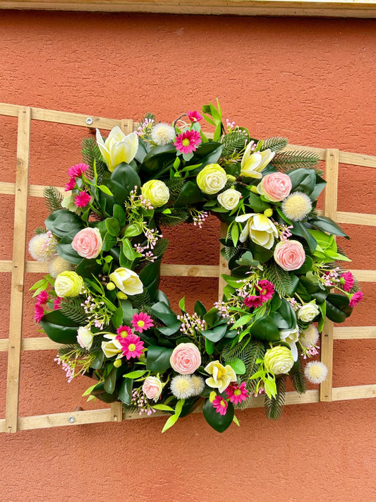 Couronne de printemps en plantes et de fleurs artificielles.