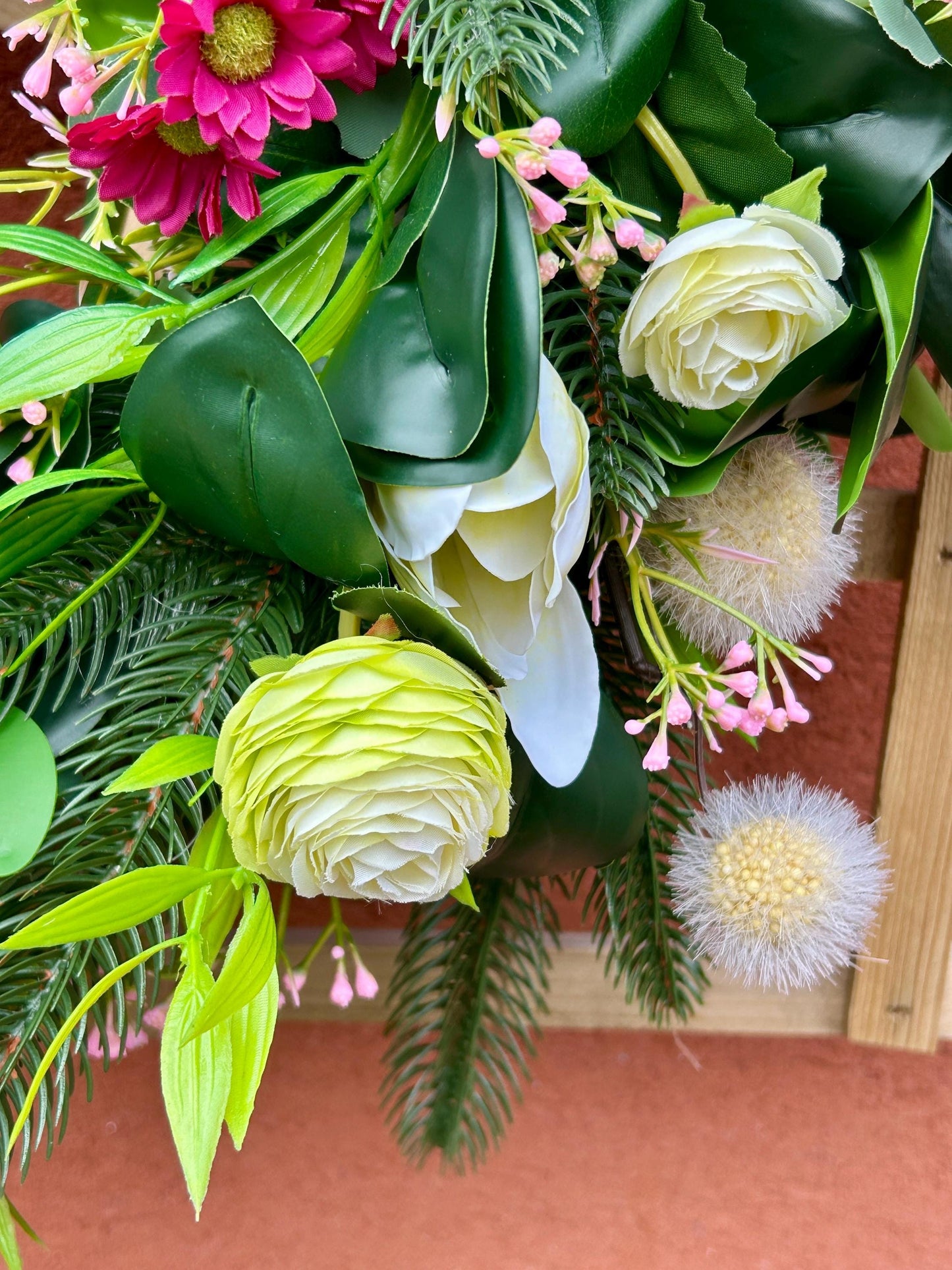 Couronne de printemps en plantes et de fleurs artificielles.