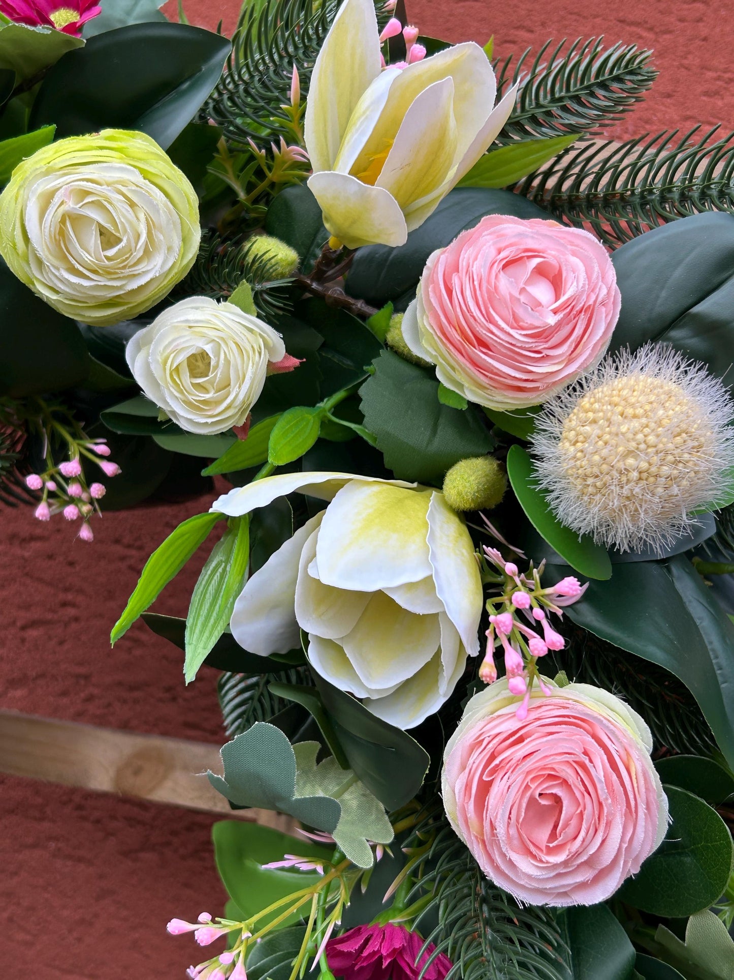 Couronne de printemps en plantes et de fleurs artificielles.